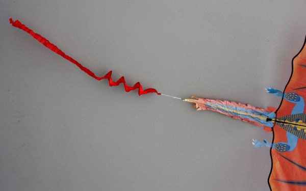 Single string fire dragon kids kite showing detail of spinsock tail addition